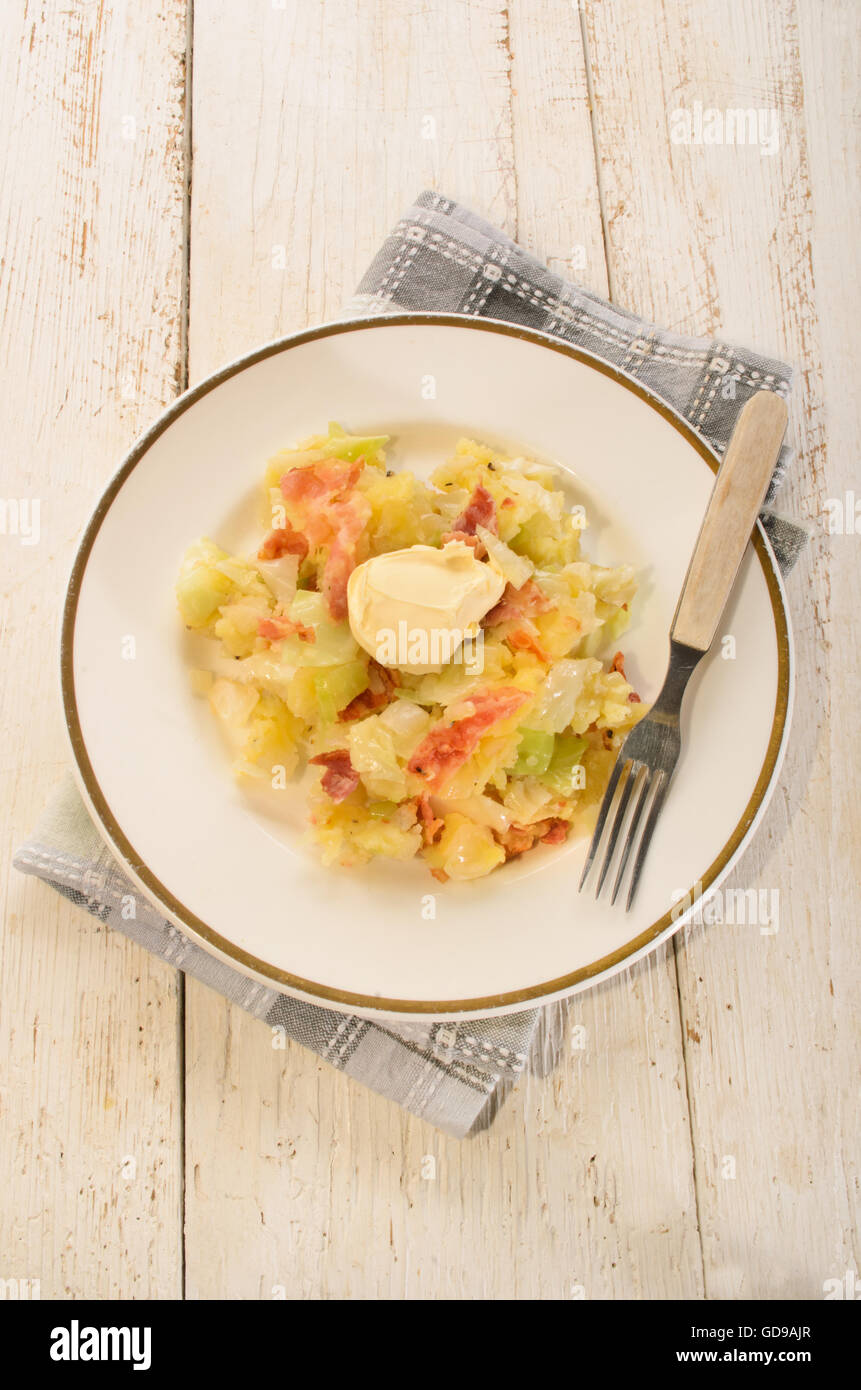 irish colcannon with butter, made with mashed potato, cabbage, grilled bacon and crushes peppercorn, fork on a plate Stock Photo