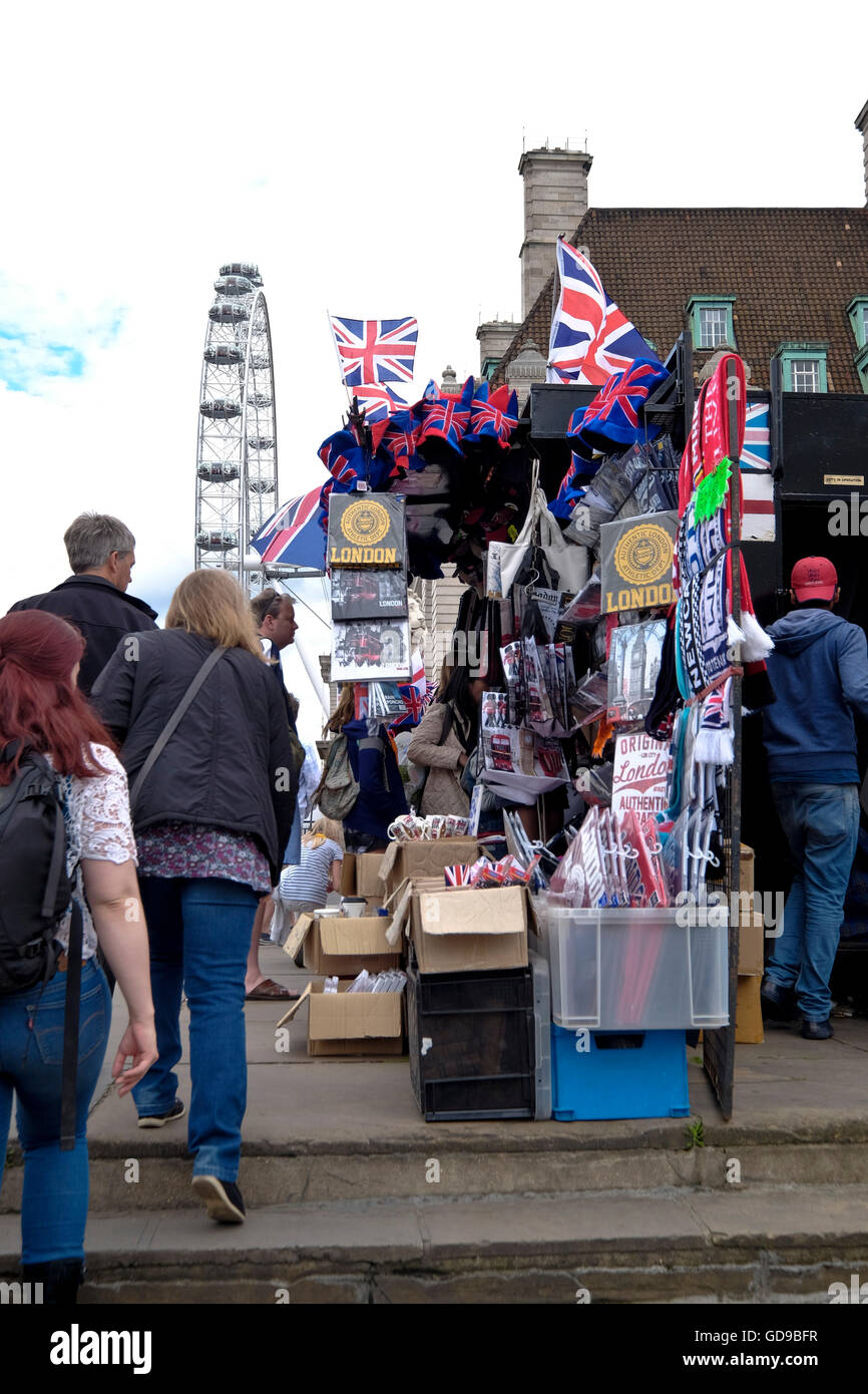 A street vendor selling souvenirs with the London Eye a London landmark