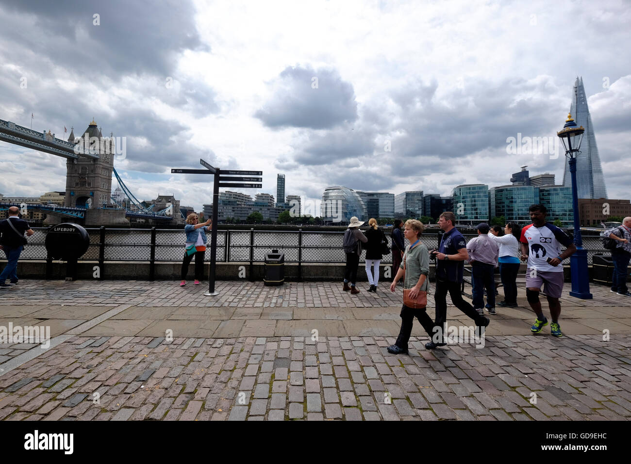 Tourists on Victoria Embankment London with London Bridge The Shard and ...