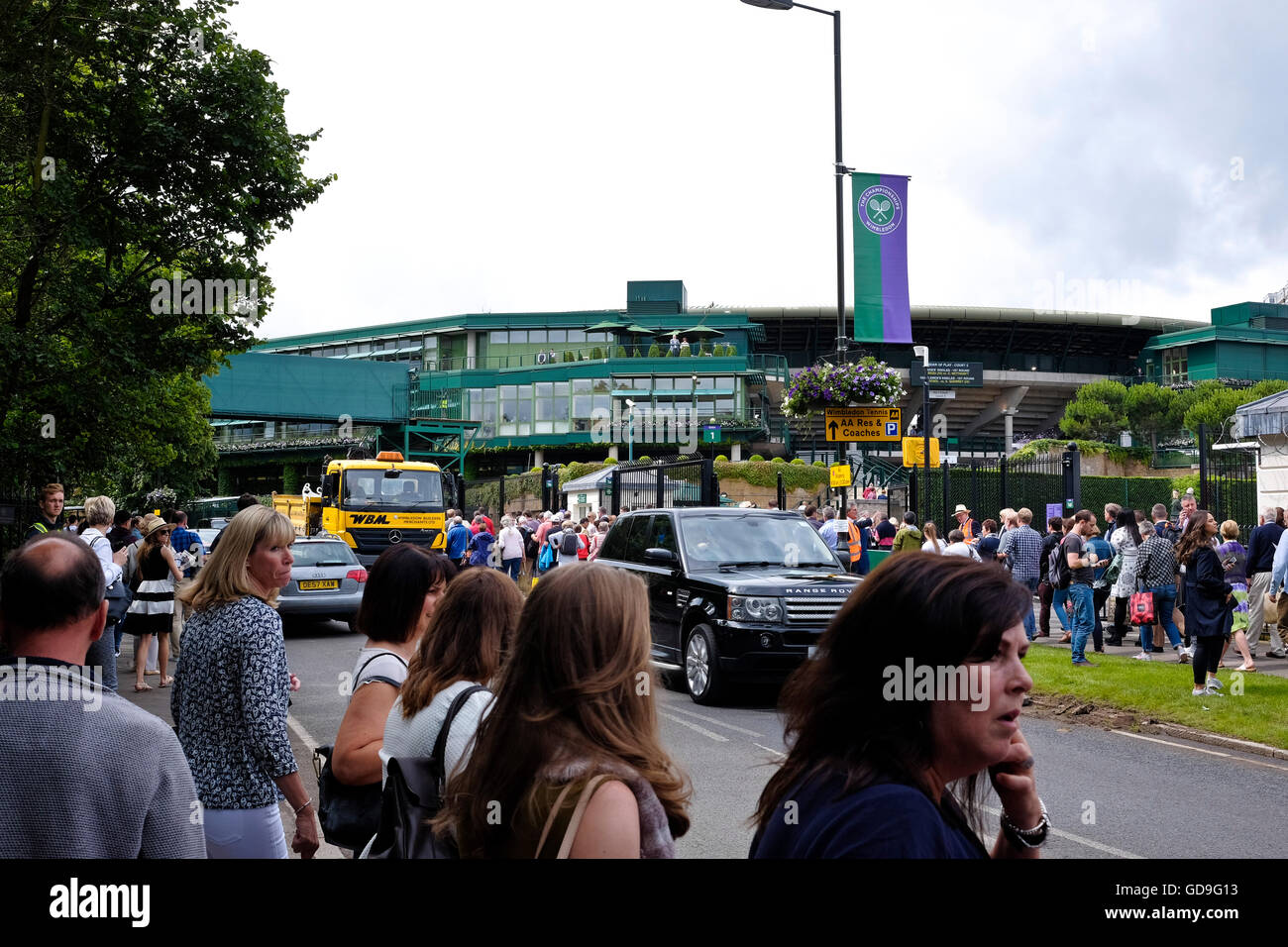 Spectators cross the road towards the stadium at Wimbledon the site of the world famous tennis tournament Stock Photo