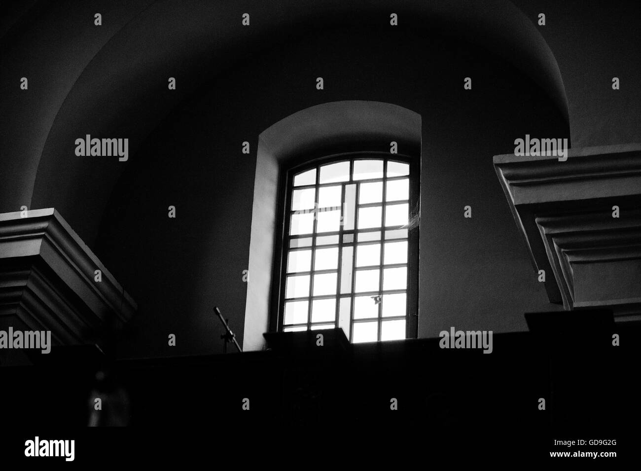 Window with cross at church and flying bird there. Black and white photo Stock Photo