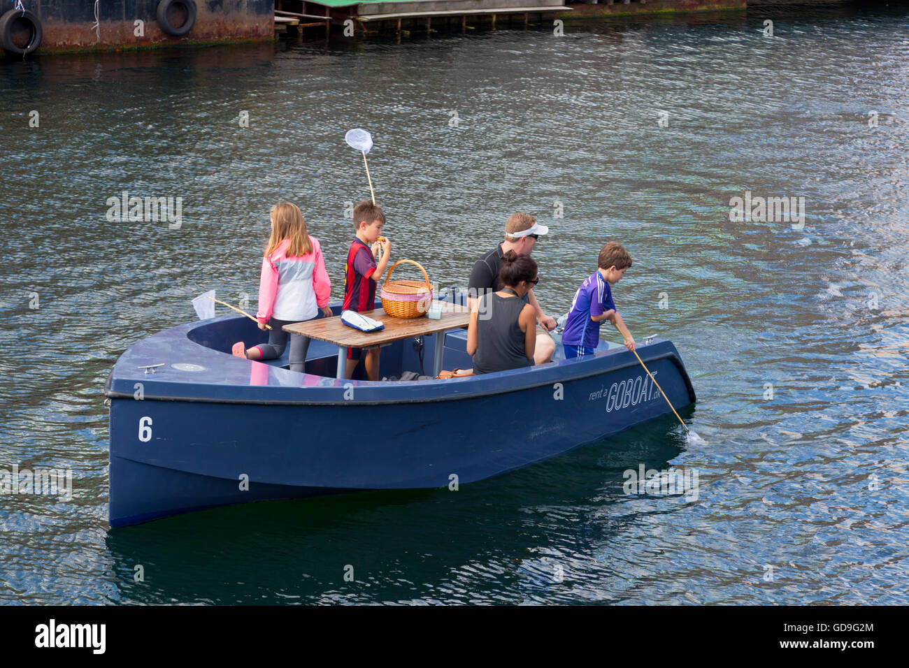 GoBoat picnic and fishing  trip in the canals of Copenhagen Harbour, Denmark. Danish hygge. Young adults and children. Stock Photo