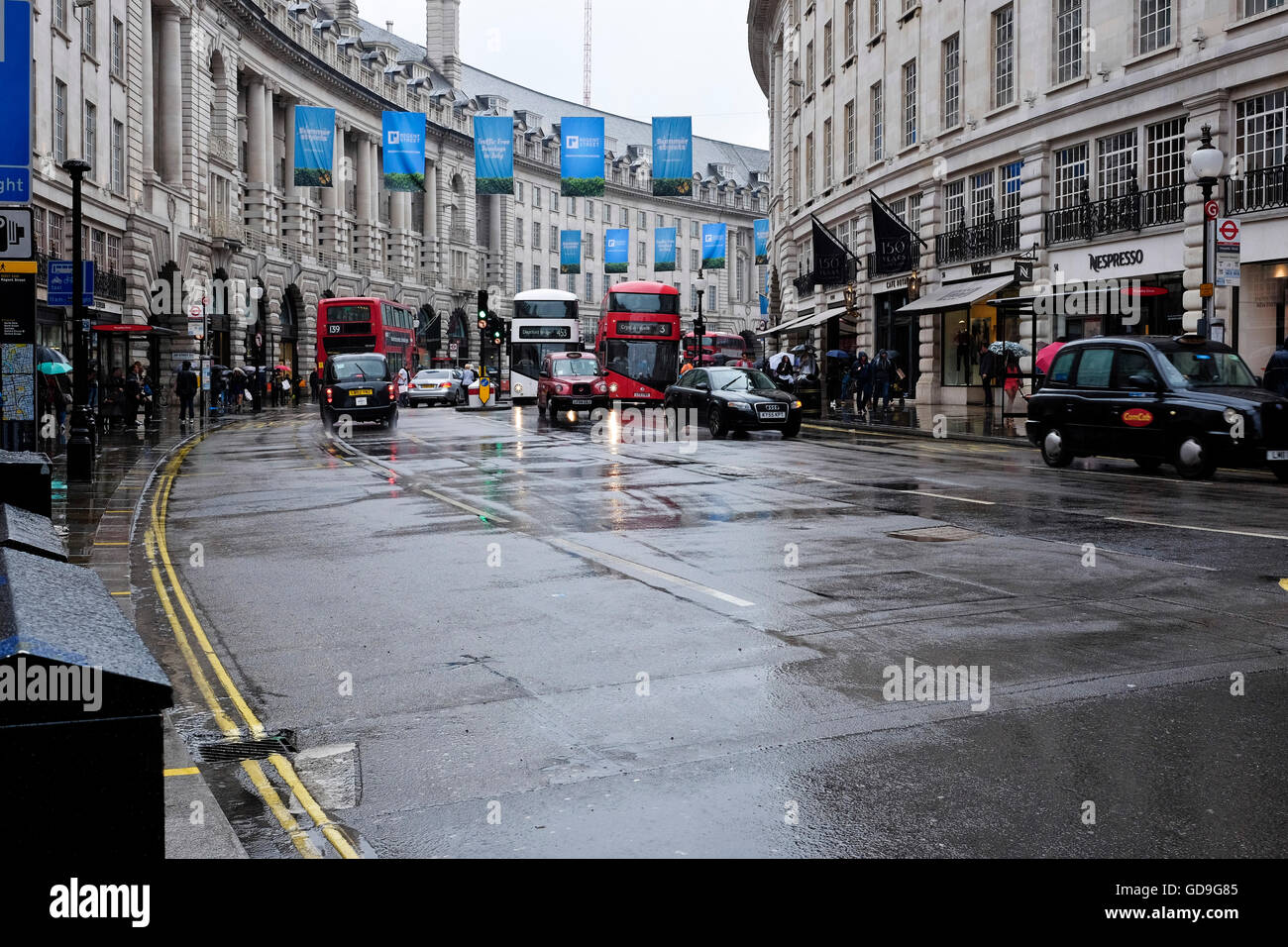 Piccadilly Circus London. London red buses on a road leading into Piccadilly Circus on a rainy day Stock Photo