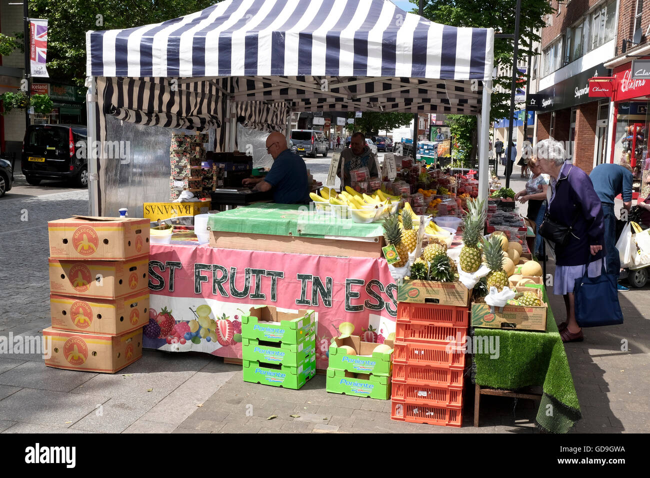 Customers buying fresh fruit from a farmers market stall set out at a