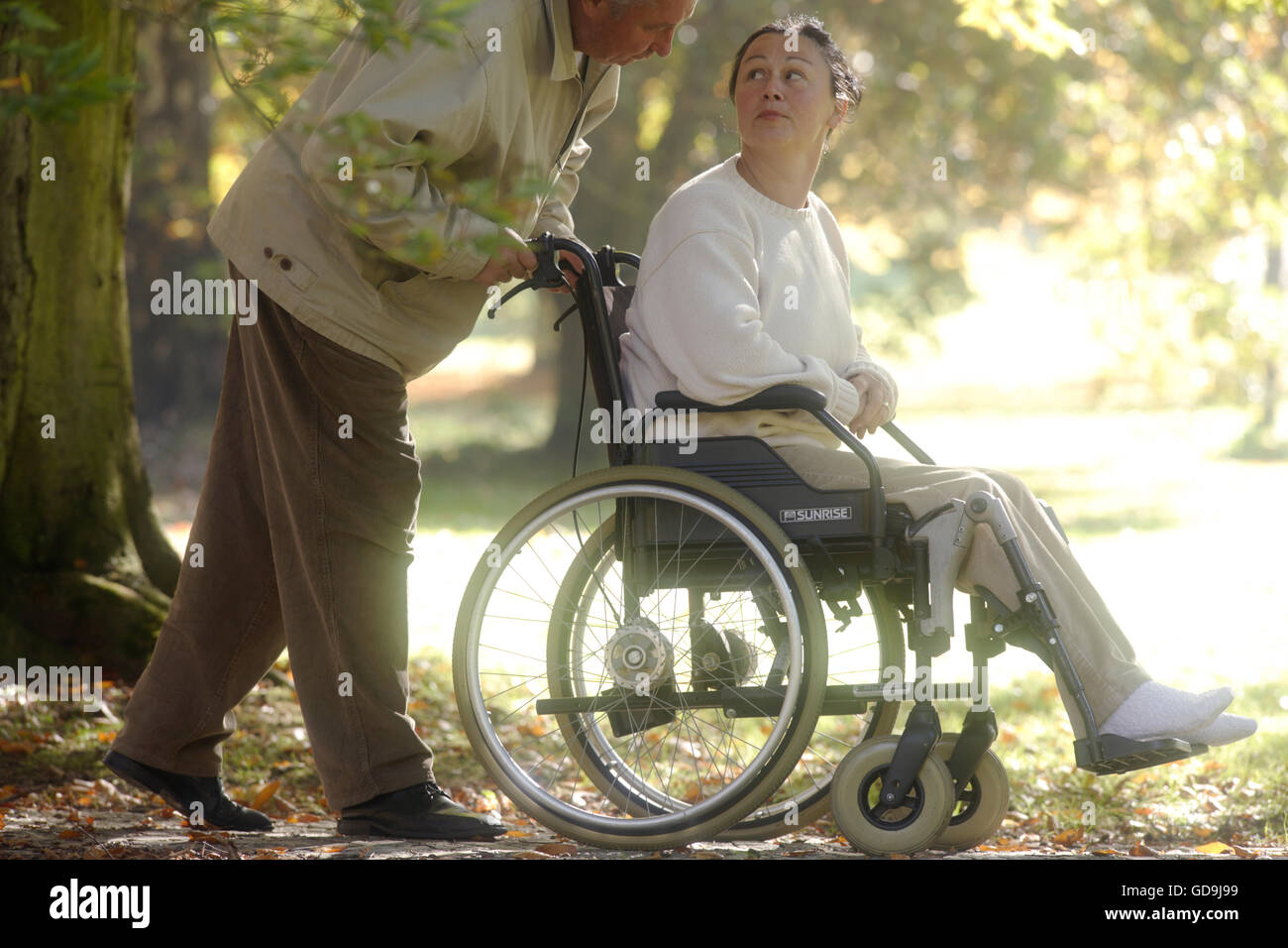 Woman in a wheelchair being pushed Stock Photo