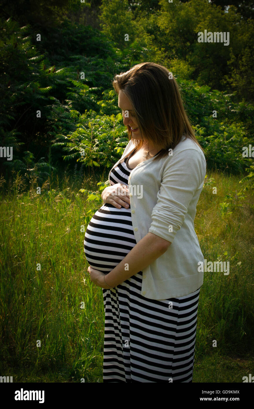 An expectant mother cradling her unborn baby Stock Photo