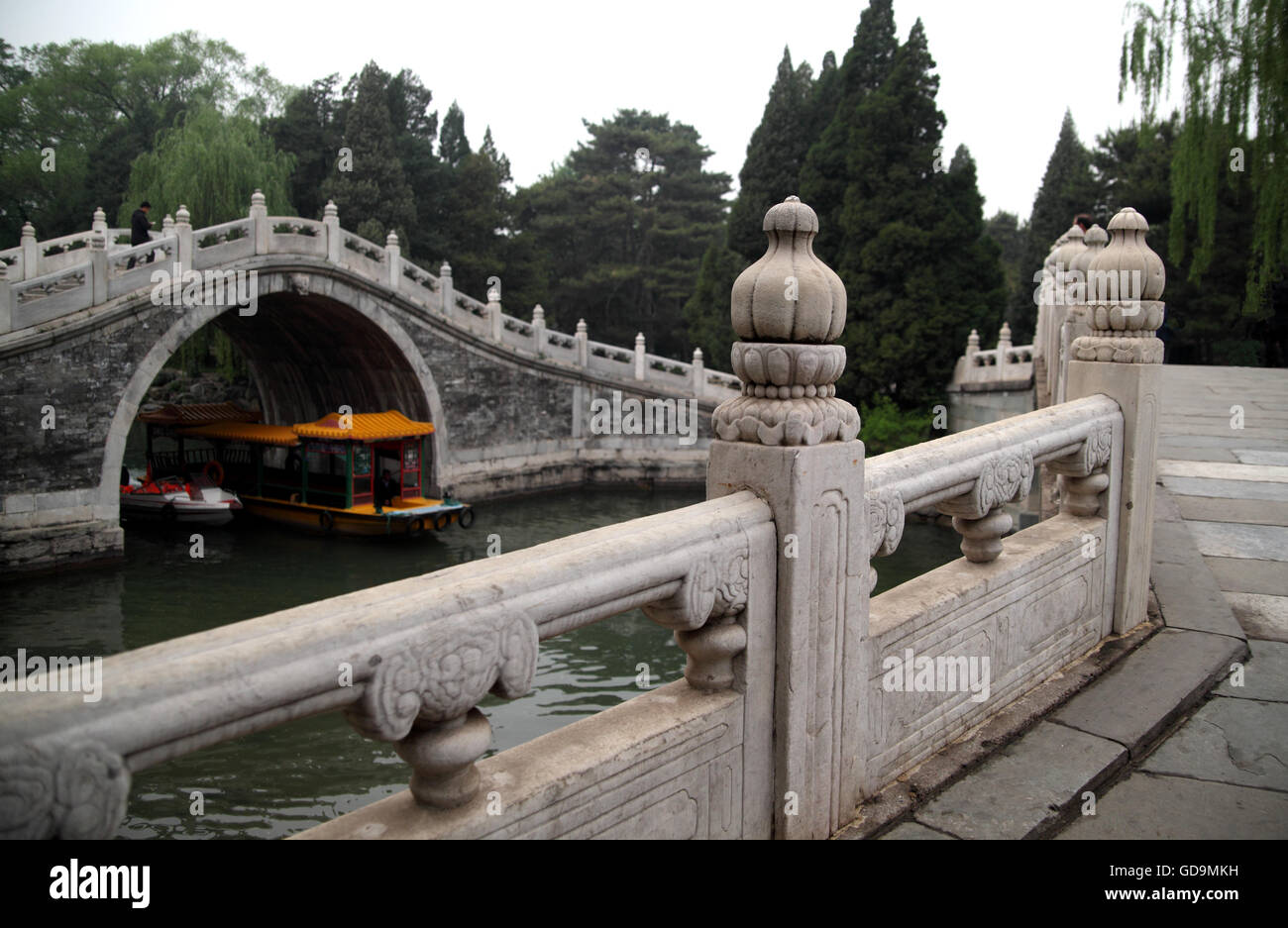 The architecturally ornamented and beautiful Jade Belt Bridge in the Summer Palace with boats going under. Beijing, China. Stock Photo