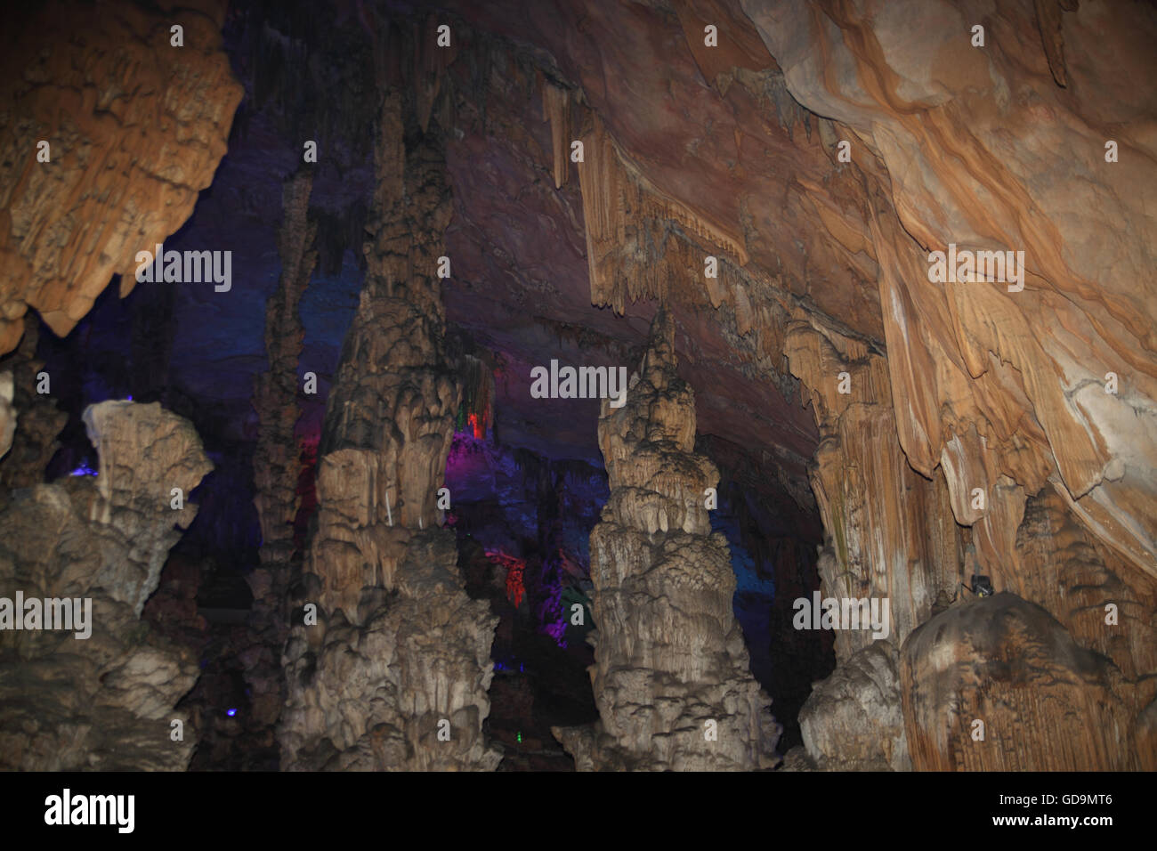 Stalagmites and rock formations coming up from the floor of the Reed Flute Cave, a natural limestone cave, a karstic phenomena. Stock Photo