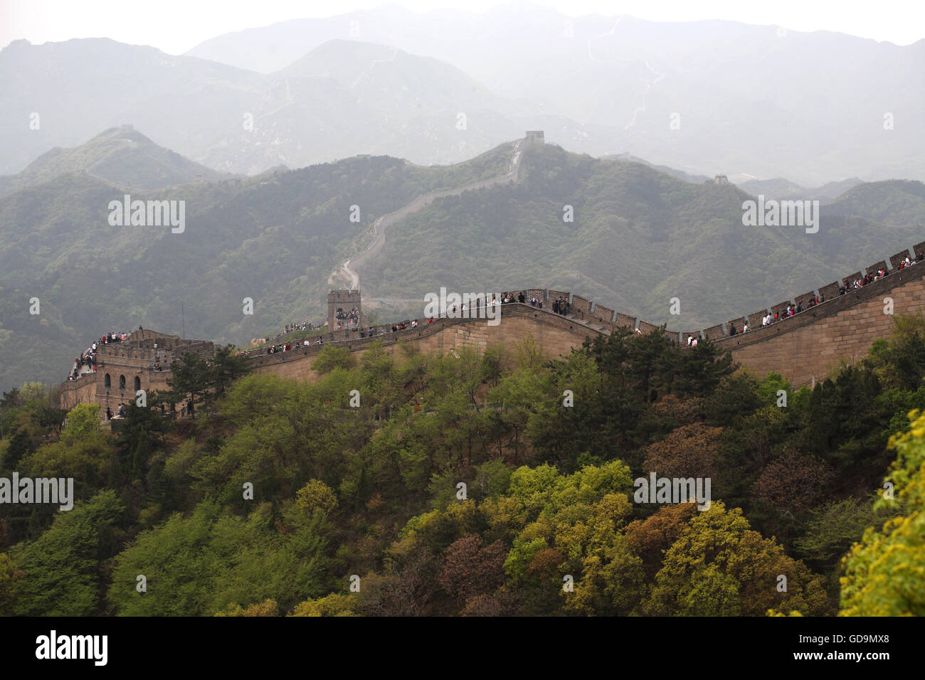 The Great Wall of China sprawls over the rugged mountains with thousands of tourists from all over the world on it. Badaling near Beijing, China. Stock Photo