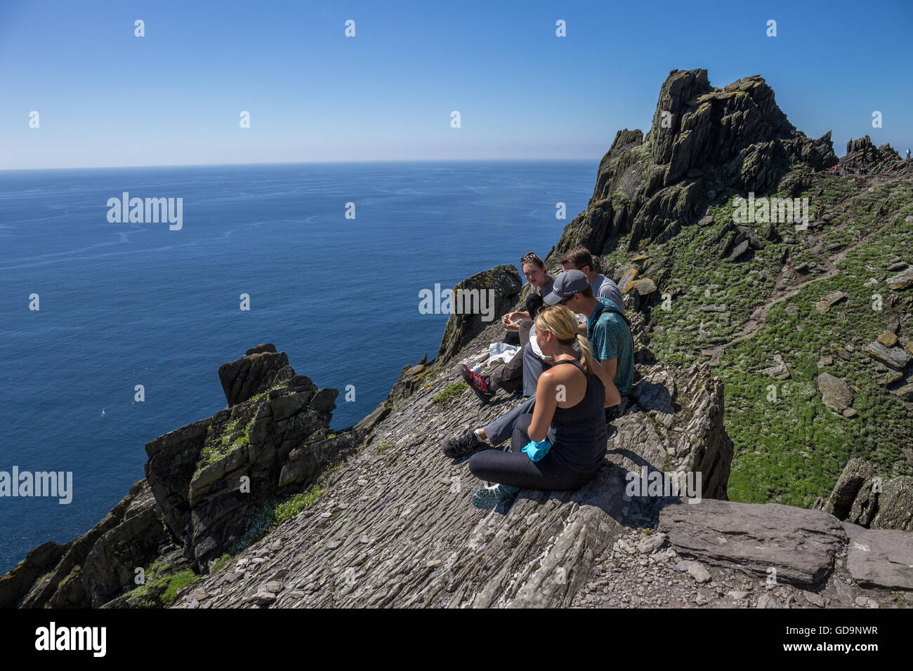 Group of tourists enjoys lunch on Skellig Michael, Irish island where Star Wars: The Force Awakens was filmed, Ring of Kerry. Stock Photo