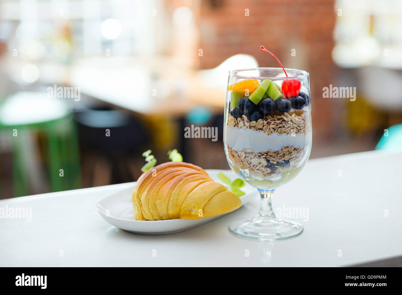 Healthy fruit cereal and croissant breakfast in modern hotel restaurant. Blurred background. Stock Photo