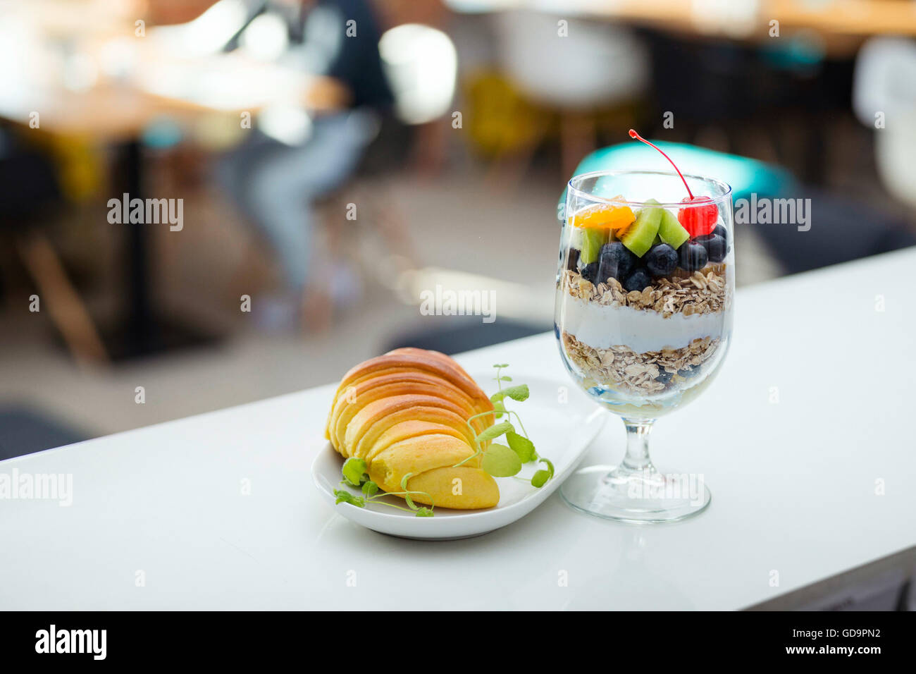 Healthy fruit cereal and croissant breakfast in modern hotel restaurant. Blurred background. Stock Photo