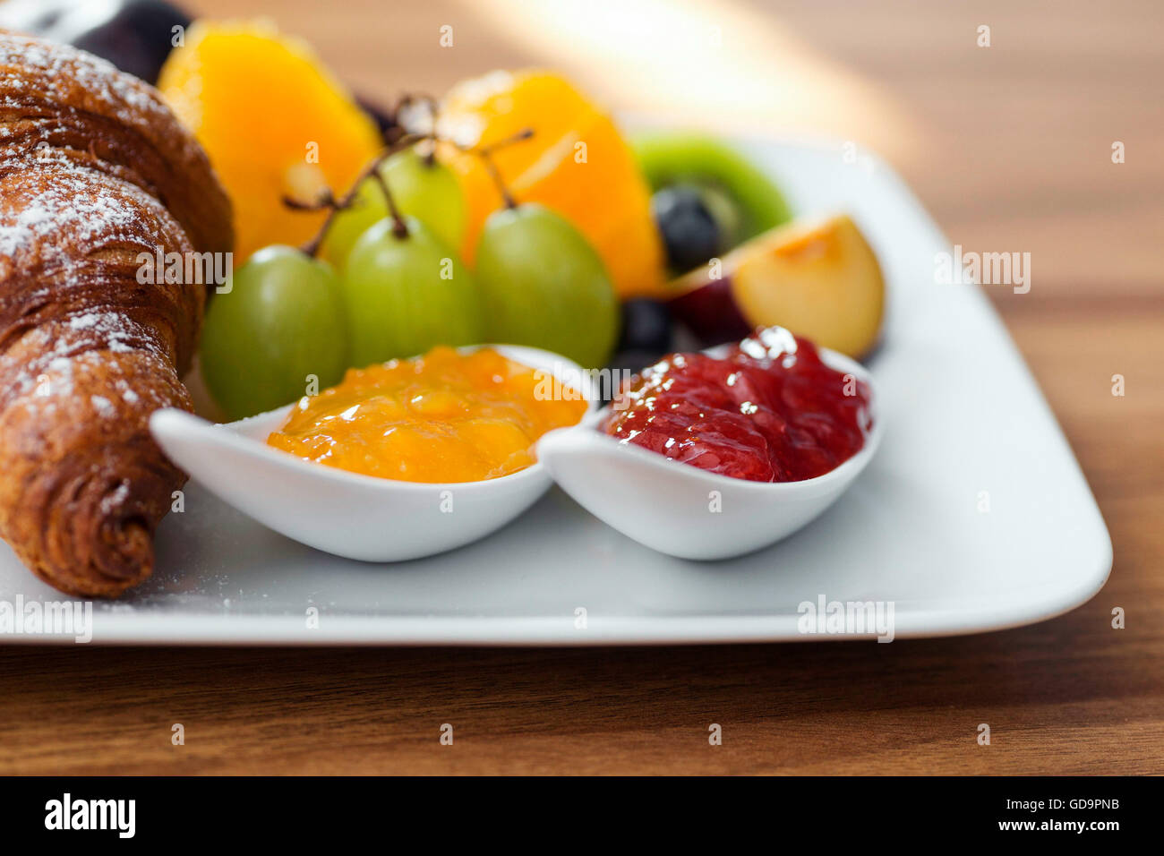 Continental breakfast with fresh fruit, jam and croissant Stock Photo