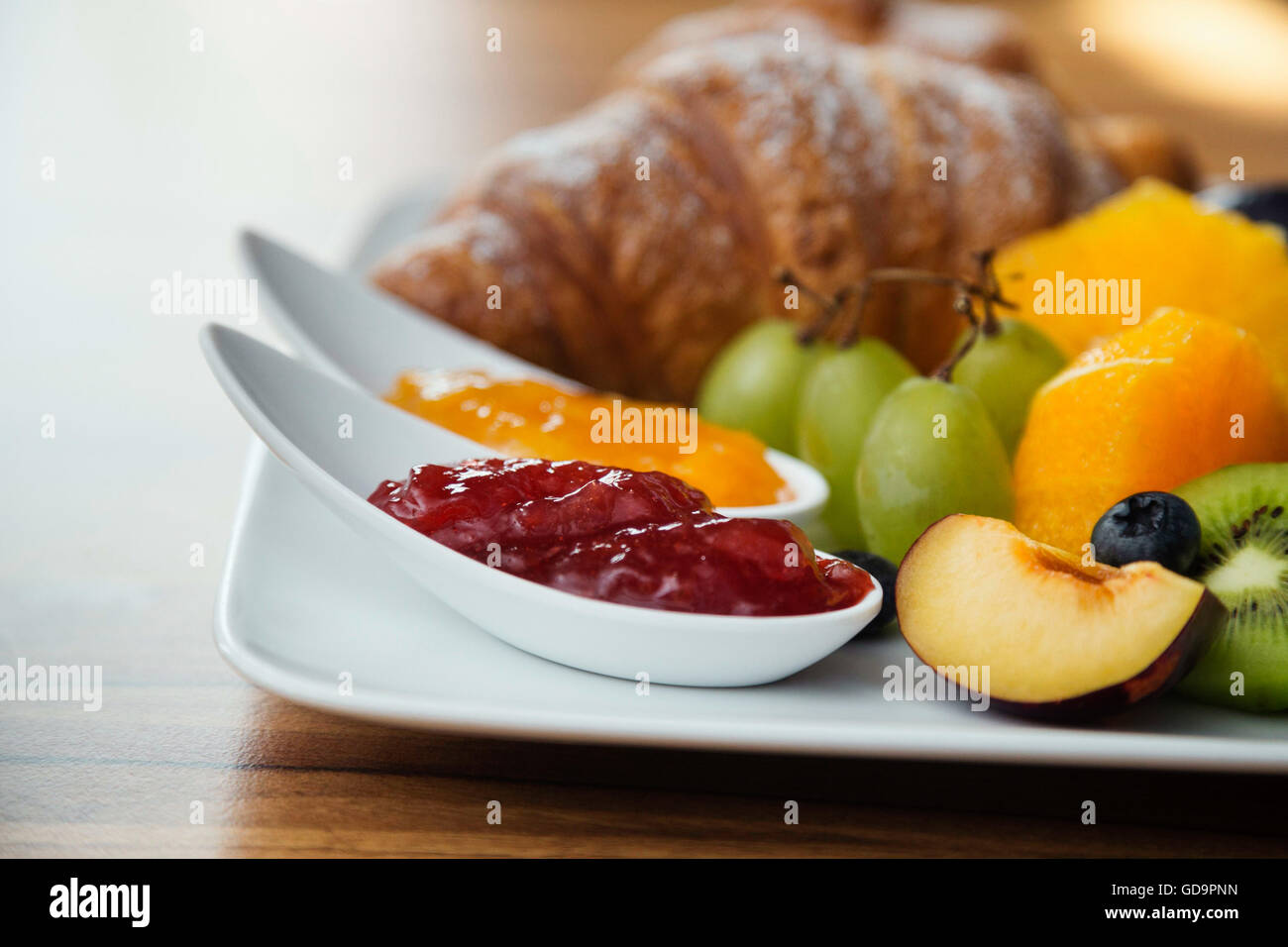 Continental breakfast with fresh fruit, jam and croissant Stock Photo