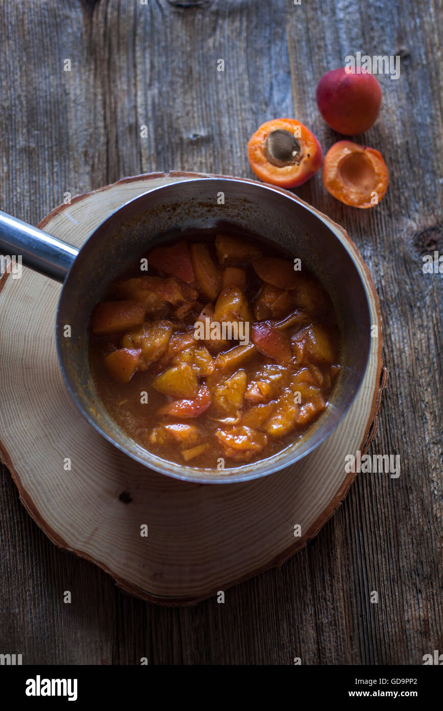 Apricots cooked with vanilla, cinnamon and maple syrup in a saucepan Stock Photo