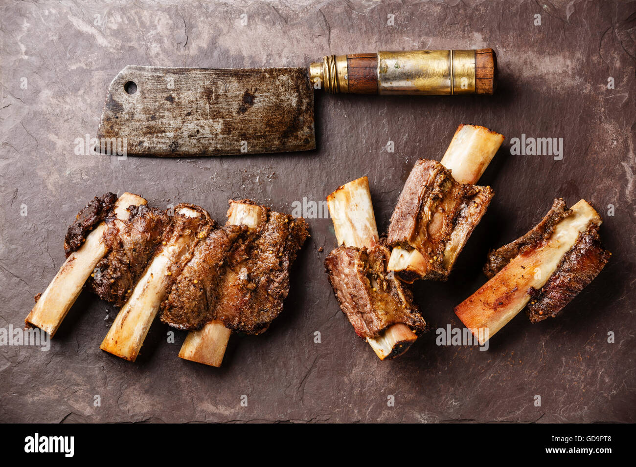 Beef Ribs BBQ and Butcher Meat cleaver on stone slate background Stock Photo