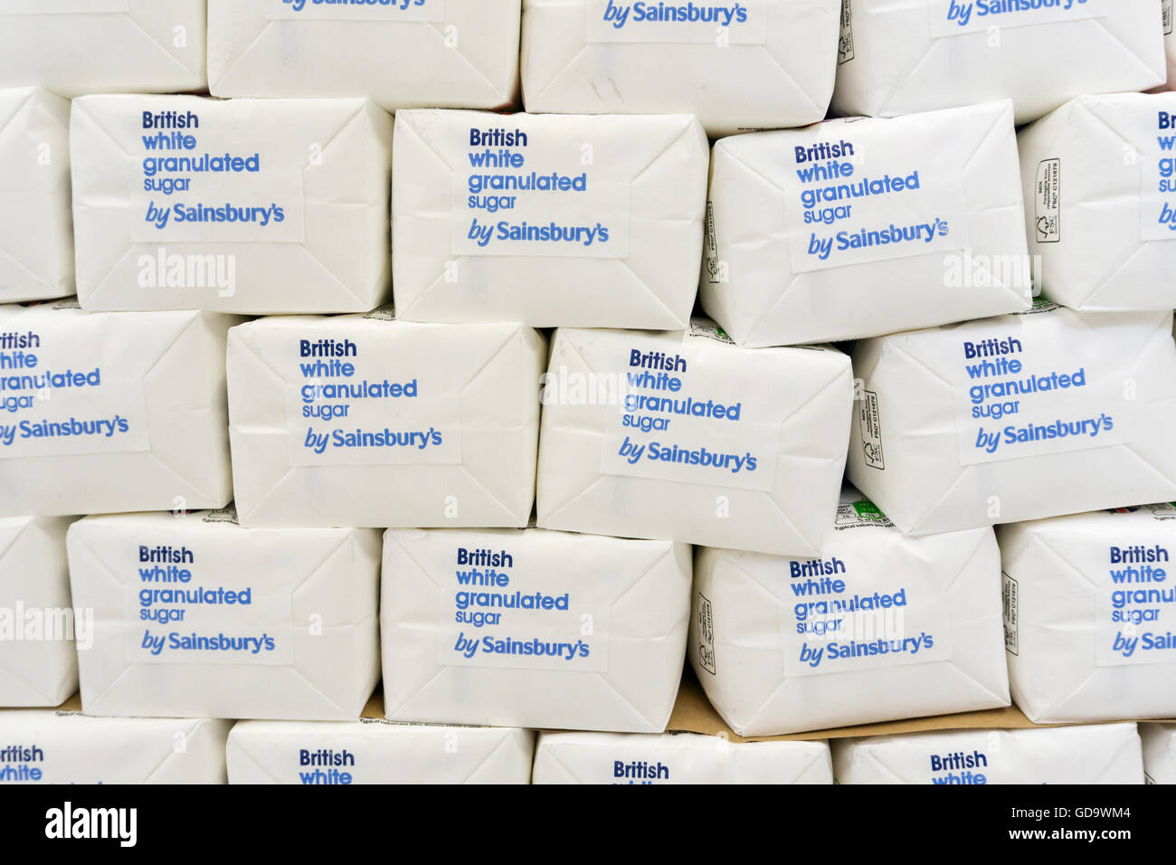 Stacks of British white granulated sugar by Sainsbury's stacked on a supermarket shelf. Stock Photo