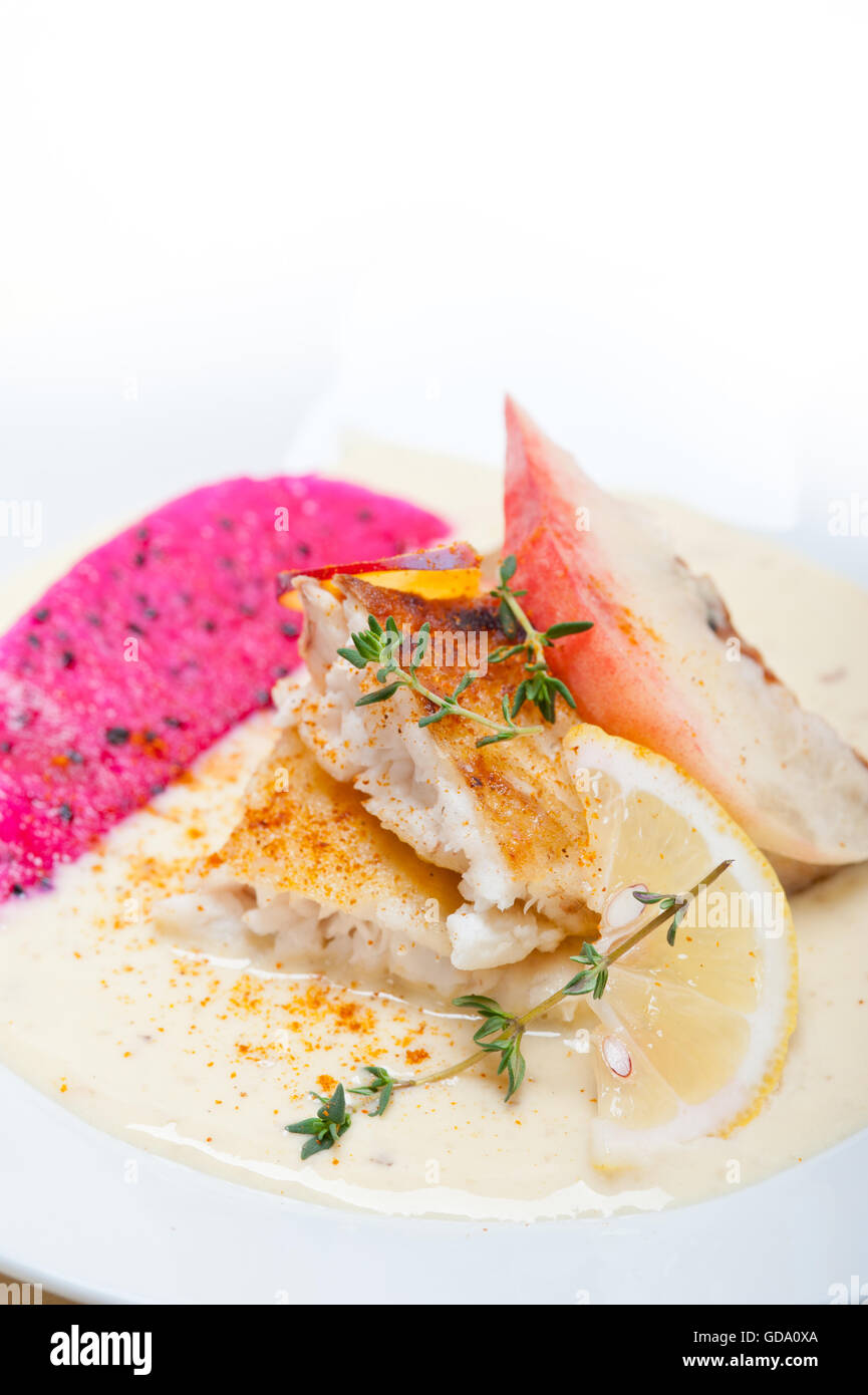 sea bream orata  fillet butter pan fried with fresh peach prune and dragonfruit slices thyme on top Stock Photo