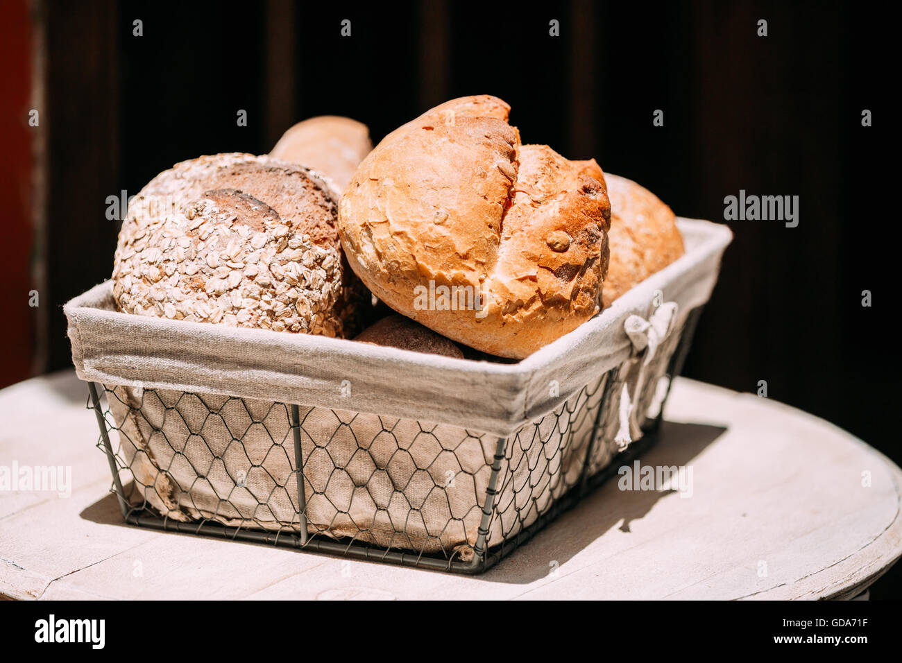 Rustic homemade bread in basket on an old vintage planked wood table ...