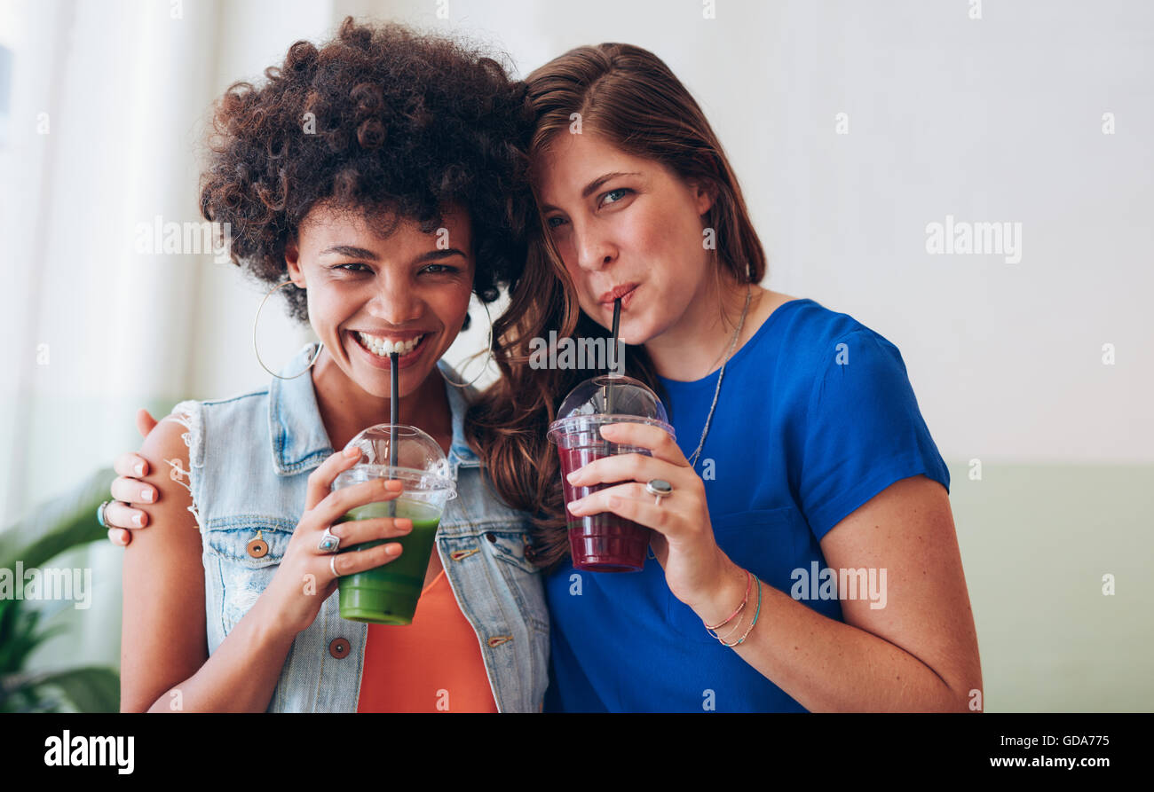 Portrait of happy young friends drinking fresh fruit juice together