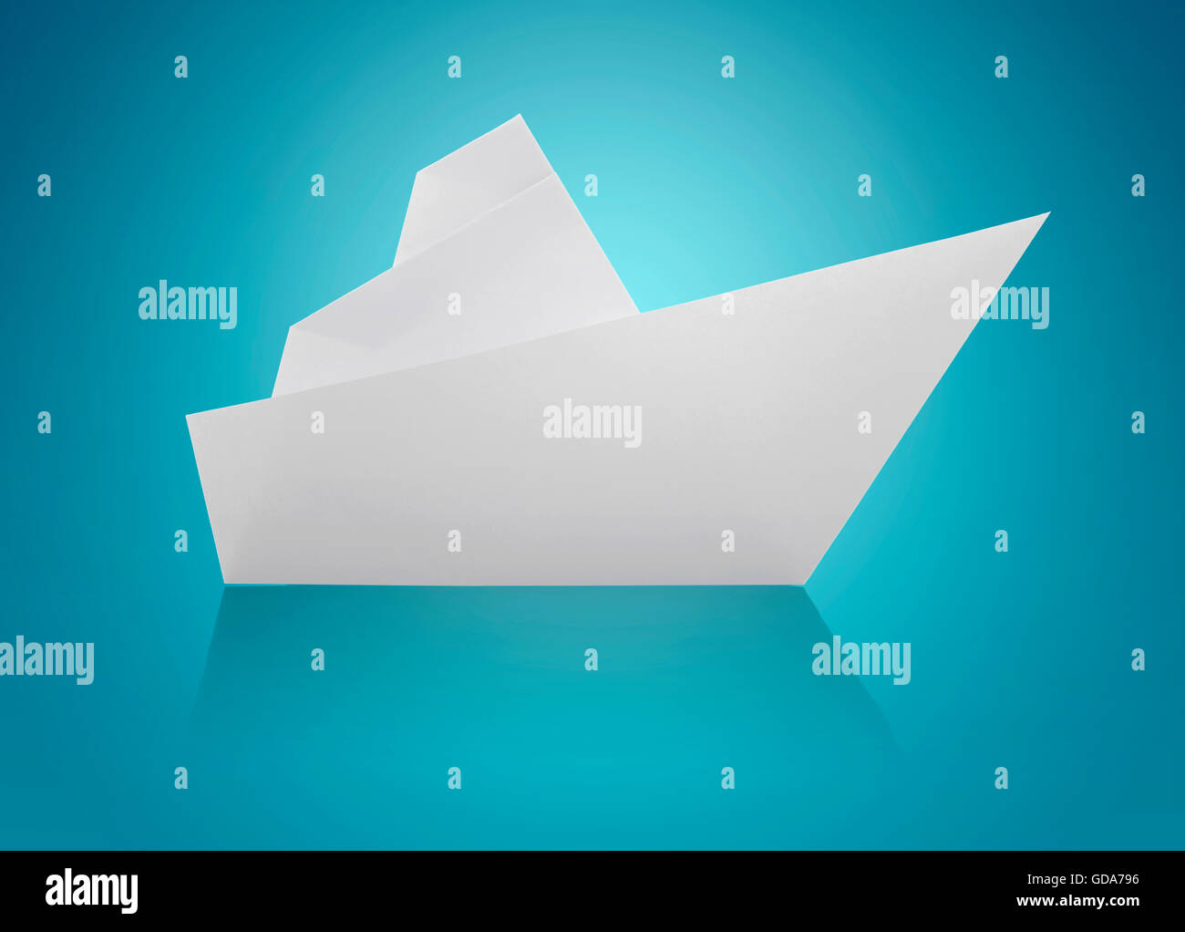 White Origami Paper Ship on Blue Background Stock Photo