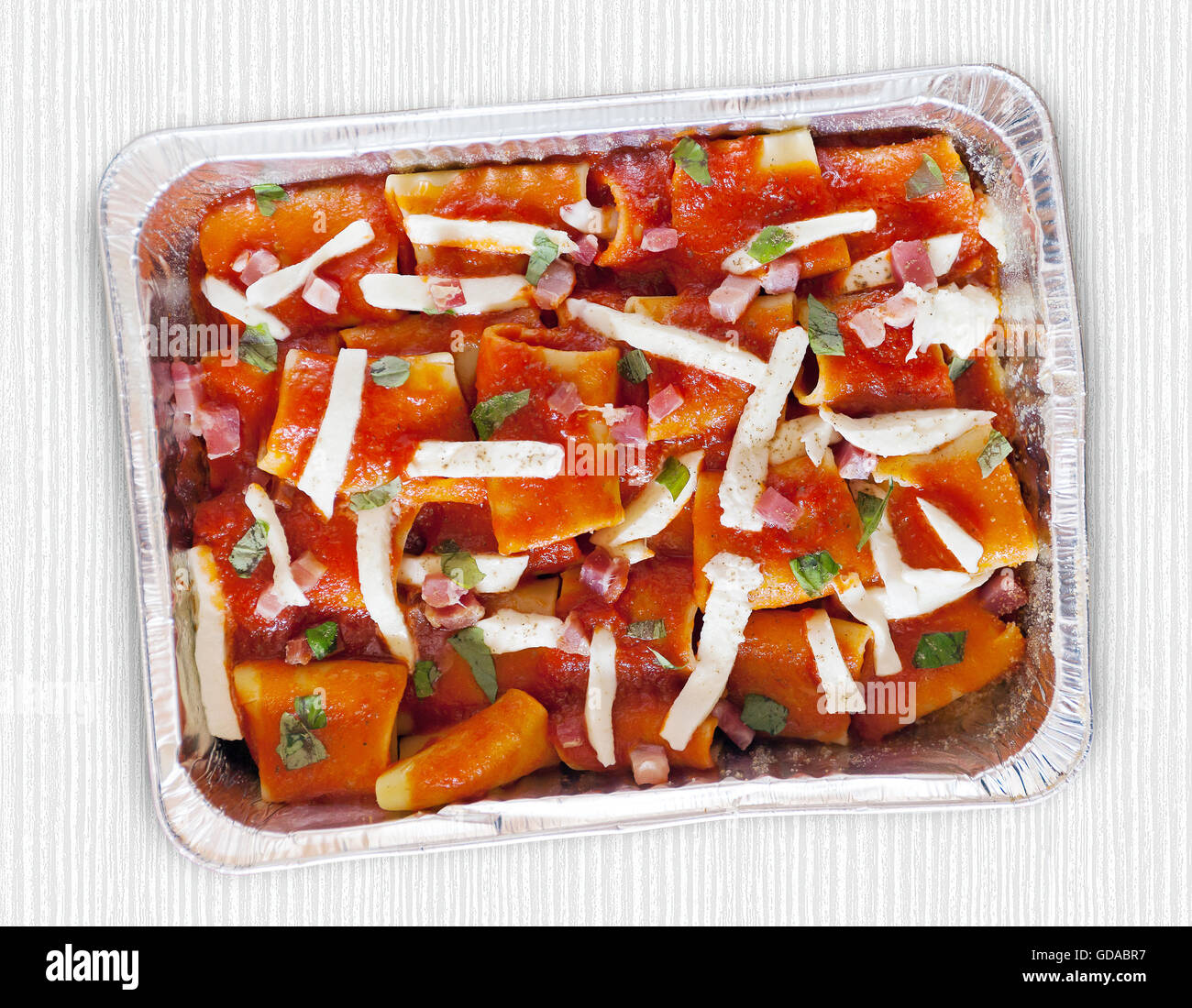 Paccheri, baked pasta with tomato sauce, mozzarella, bacon and basil. Italian culinary