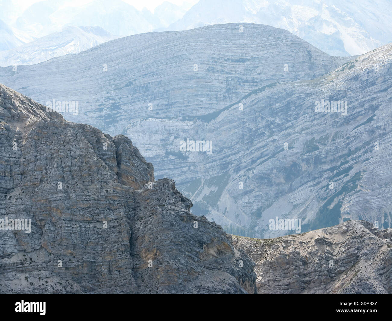 Italy, Trentino-Alto Adige, Provincia di Bolzano, rock faces, view from the summit, mountains with lying rocks in the haze Stock Photo
