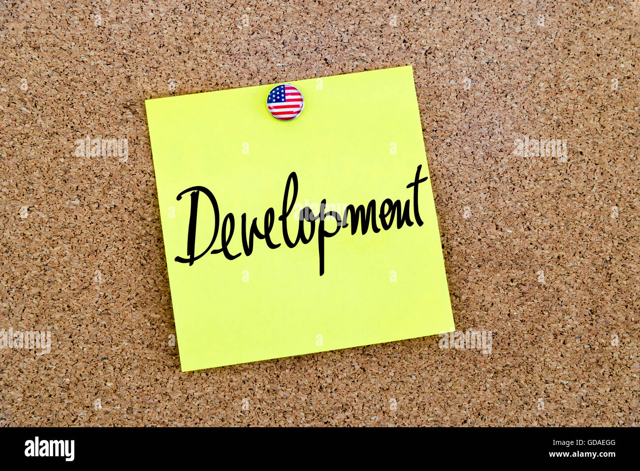 Written text Development over yellow paper note pinned on cork board ...