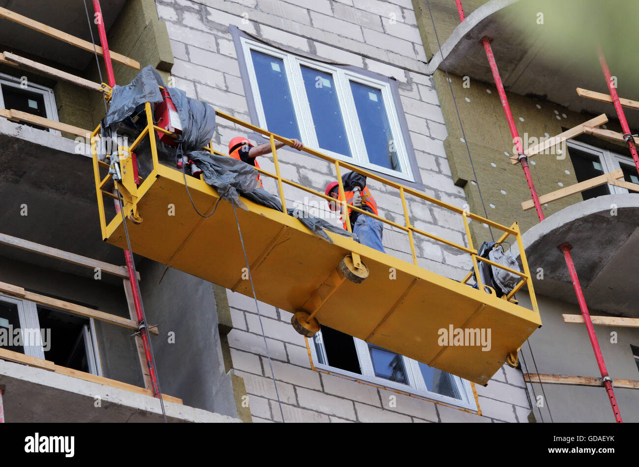 construction suspended cradle with workers on a newly built high-rise