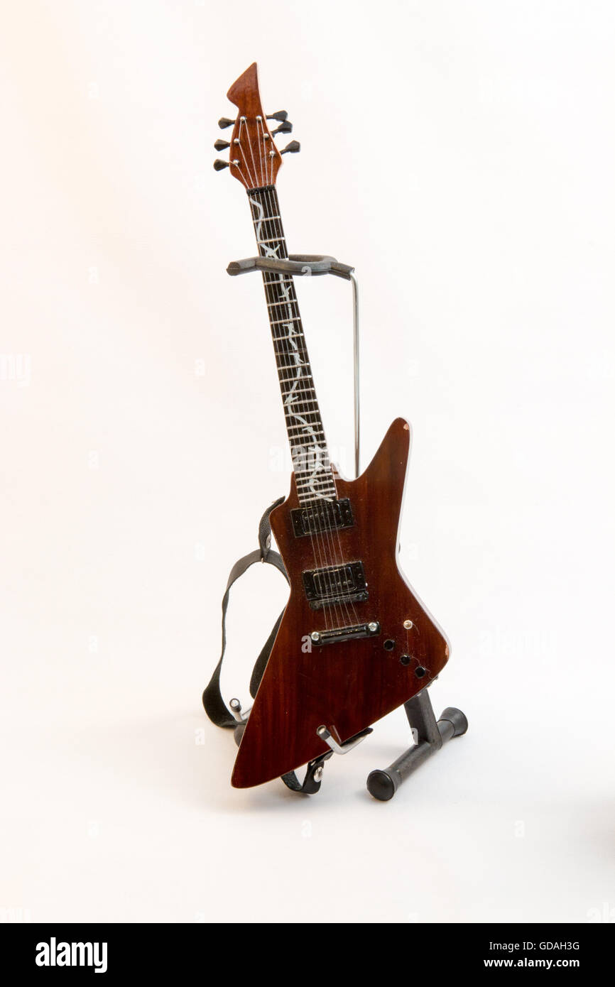 Little model guitar on a stand against a white background Stock Photo