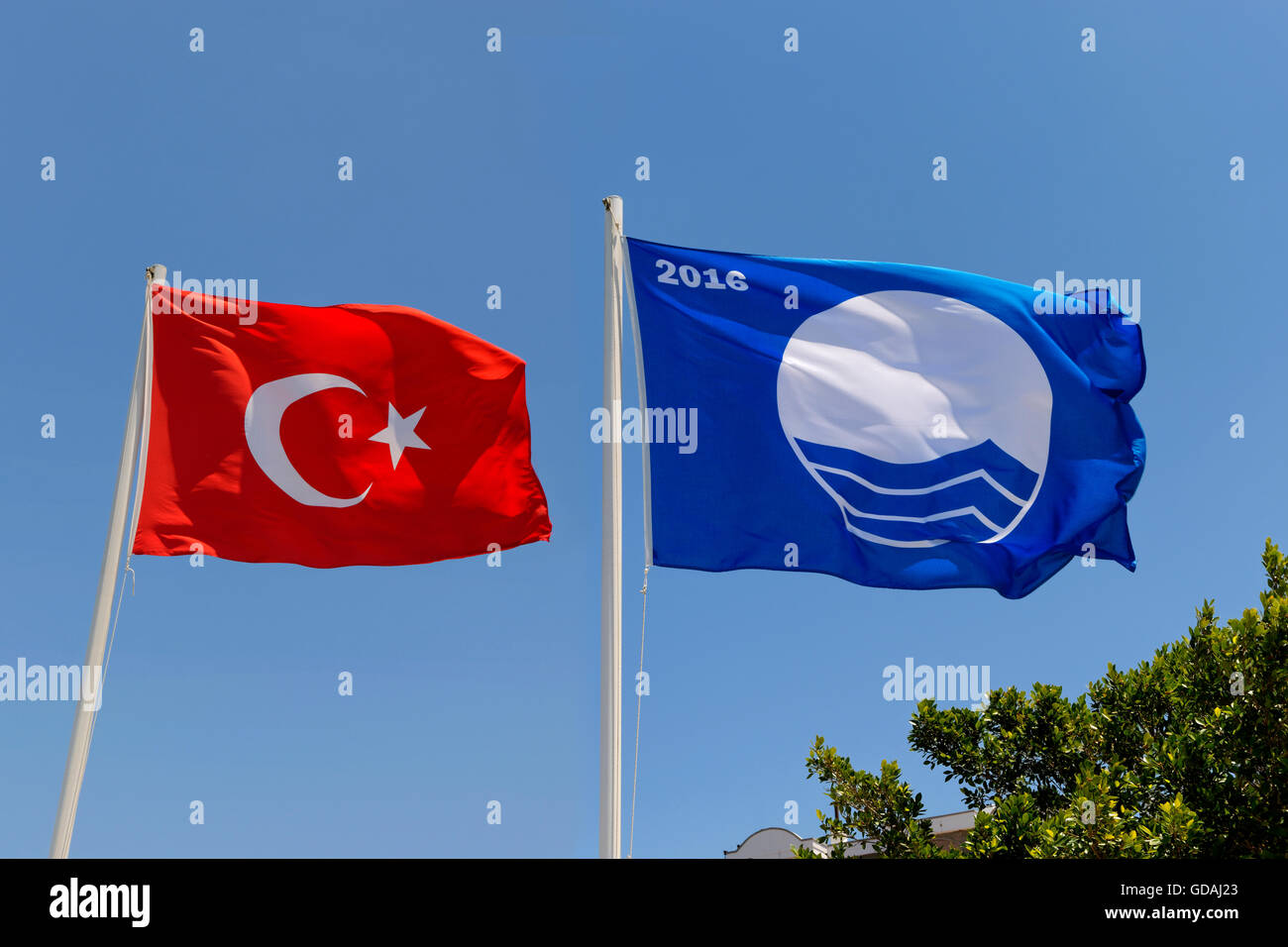 Clean beach clean water Blue Flag and the Turkish flag at Bodrum, Turkey. Stock Photo