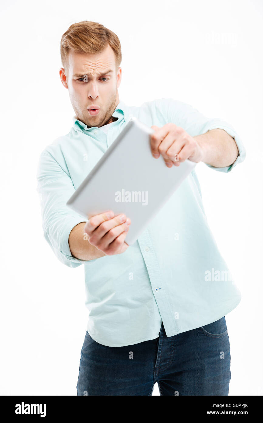 Portrait of a funny redhead man using tablet computer isolated on a white background Stock Photo