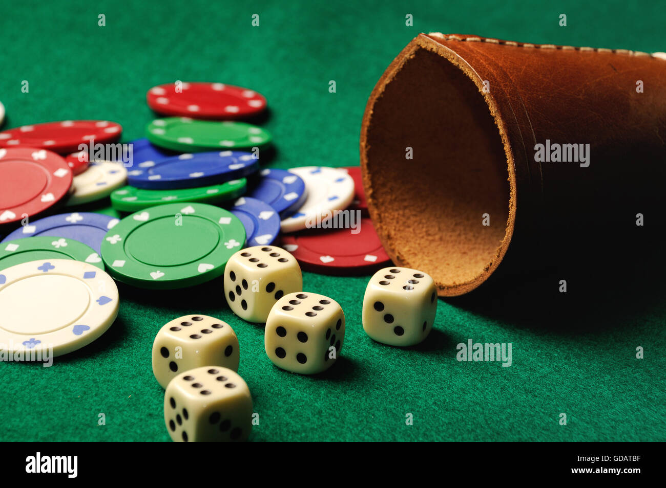 Poker dice with chips on green casino table Stock Photo