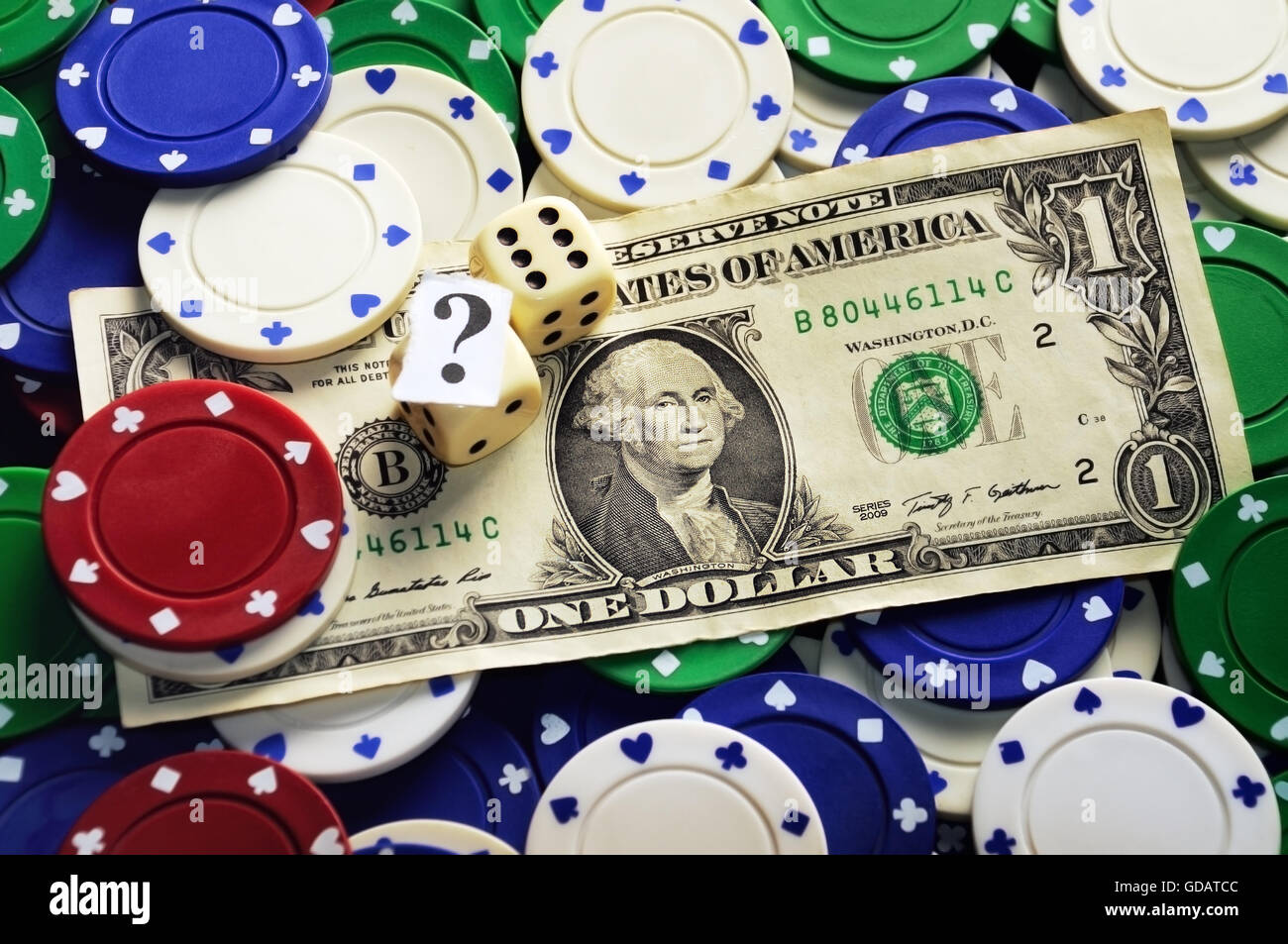 Dollar bill casino chips and dices hidden under question mark risk