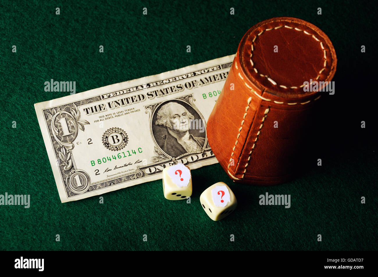 Dollar bill ,casino chips and dices hidden under question mark risk