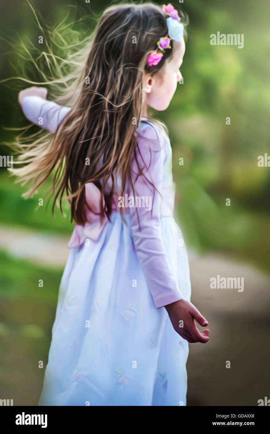 beautiful little girl in white dress dancing in nature Stock Photo