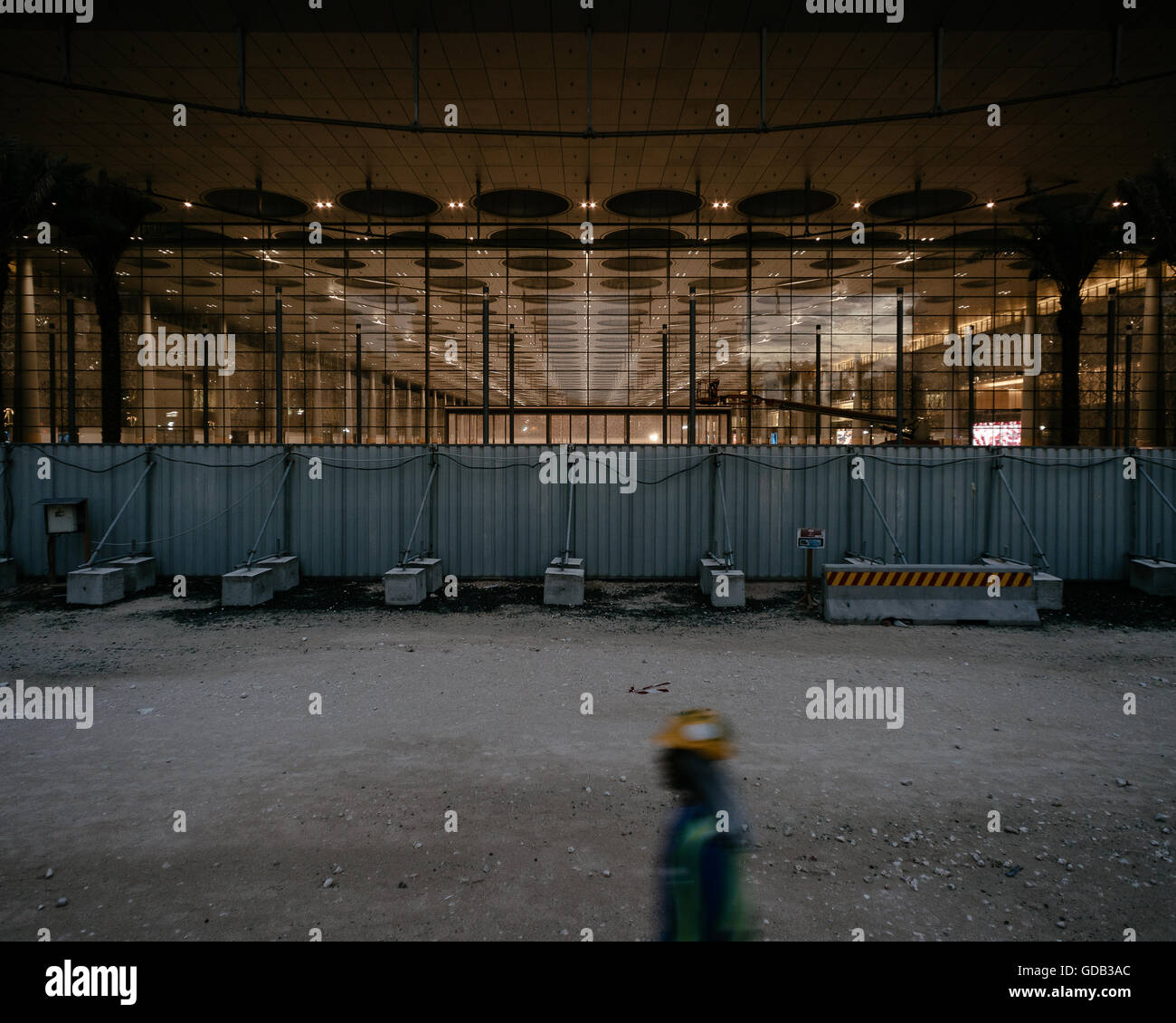 A worker walks past the under-construction Doha Exhibition and Convention Centre (DECC) in West Bay, Doha. Stock Photo