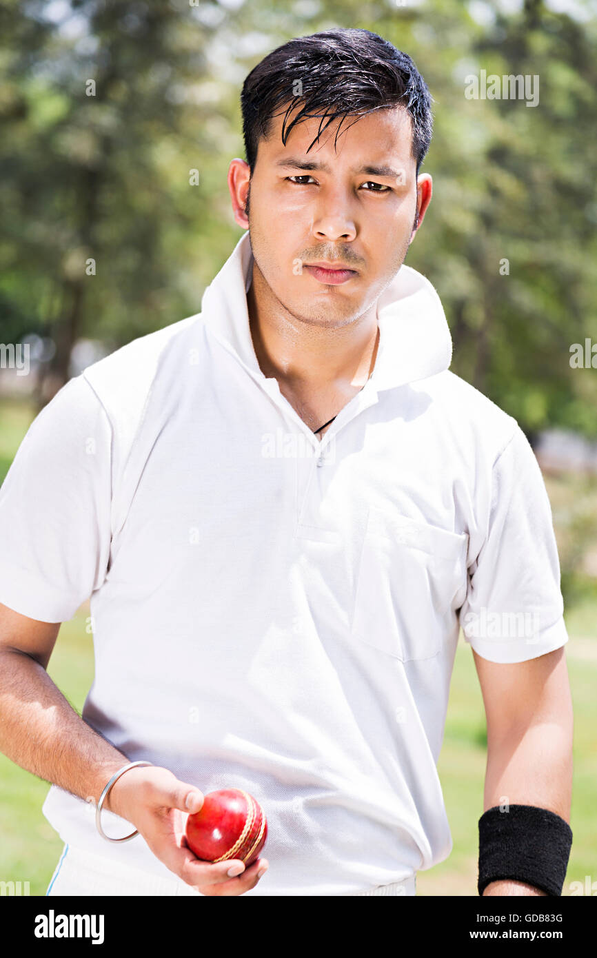 One Indian Young man Bowler Holding Ball Playing Cricket In Play Ground