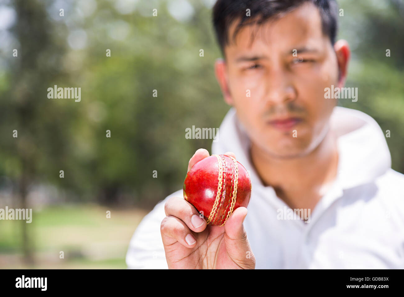 One Indian Young man Bowler Holding Ball Playing Cricket In Play Ground Stock Photo