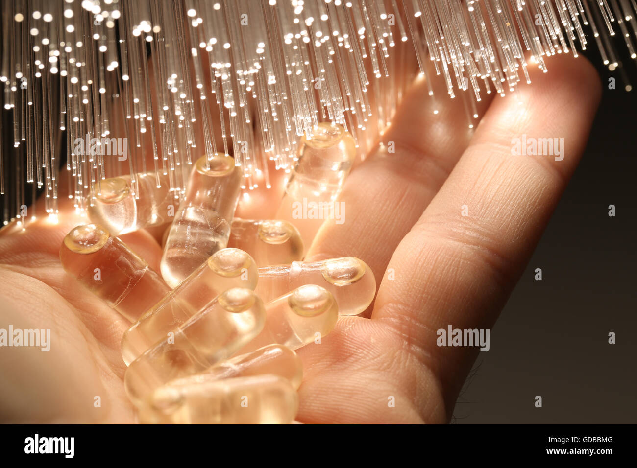 liquid capsule on fiber optical technology background Stock Photo