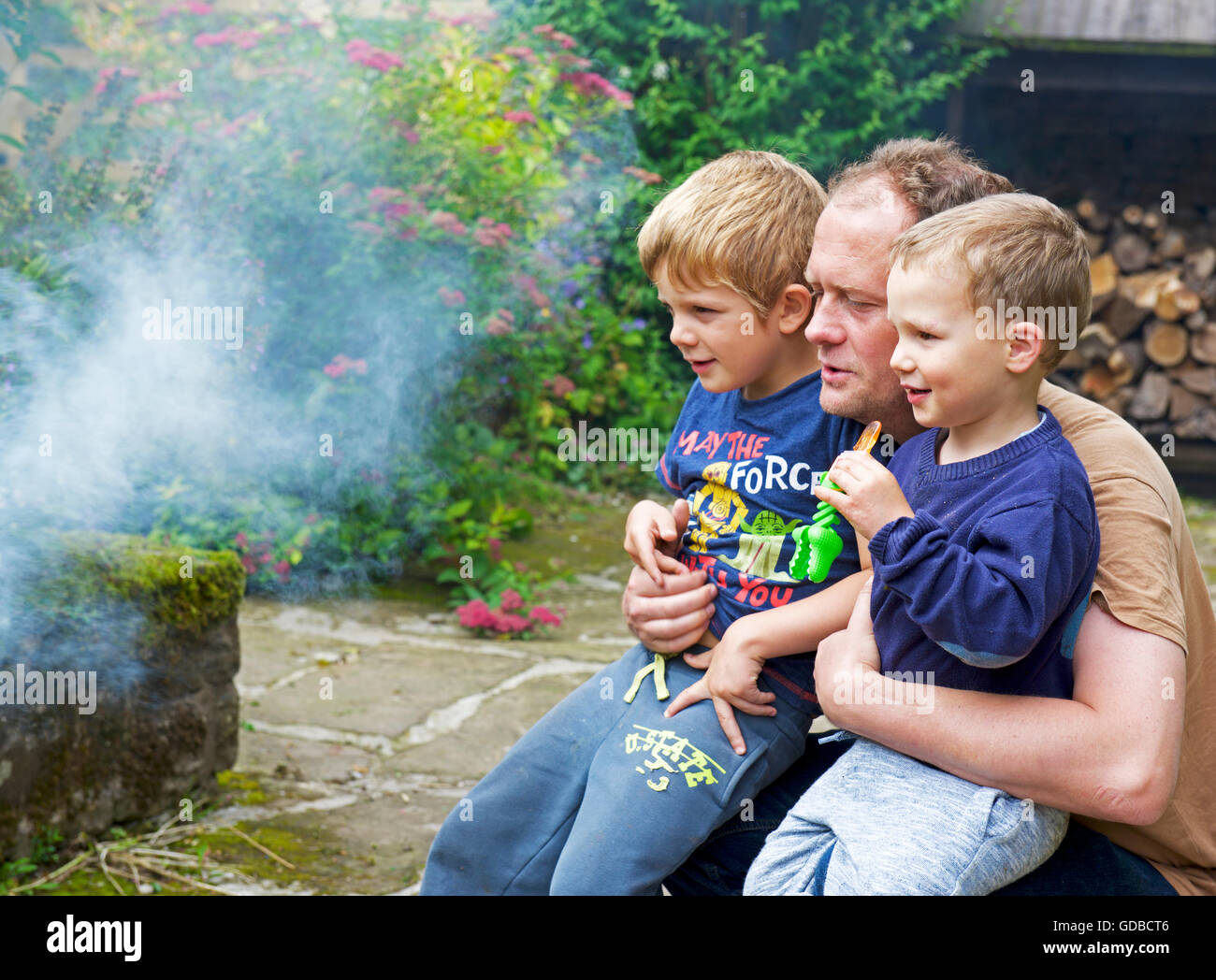 Man with two sons, watching a fire, UK Stock Photo