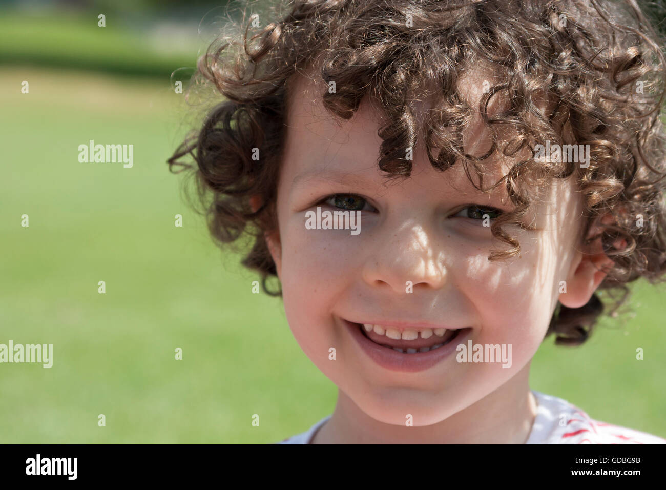Young boy smiling in the summer sun Stock Photo
