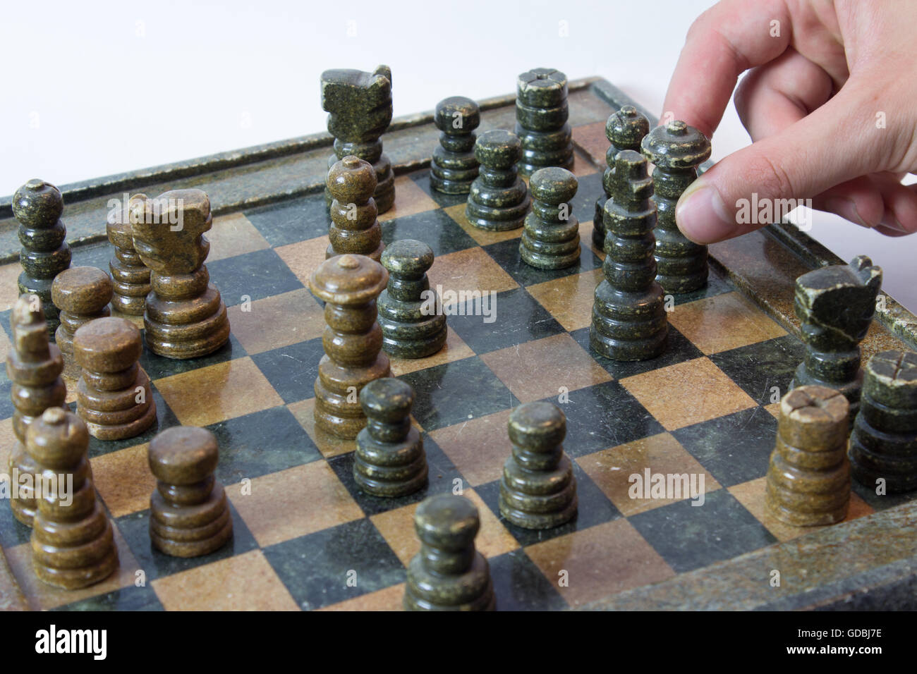 Hand Moving Queen on Chess Board Stock Photo
