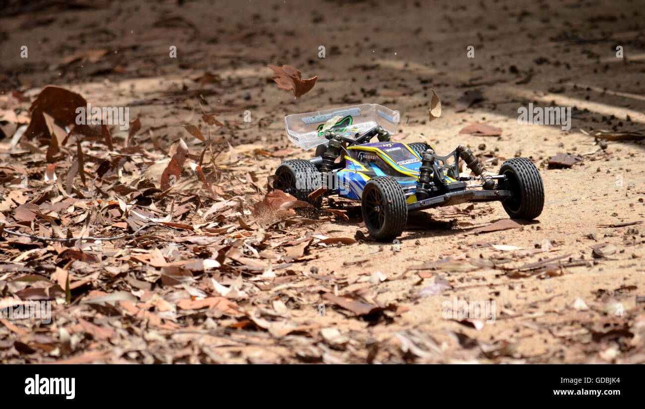 Sydney, Australia - November 30, 2014. Radio controlled buggy car model in race, internal combustion engine on a bumpy red clay  Stock Photo