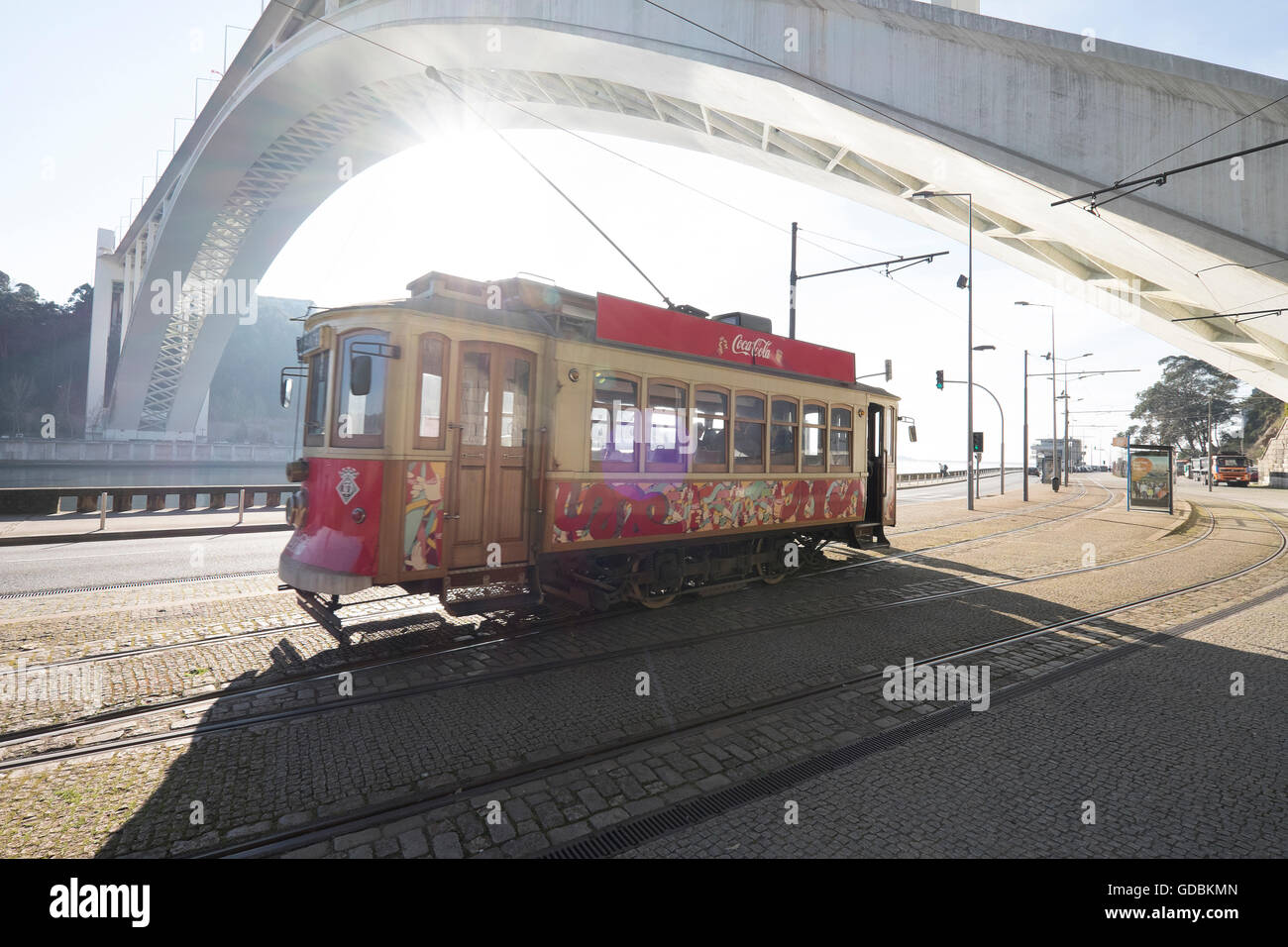 Trams at Arrabida Bridge in strong sunlight casting shadows and patterns on the street. Architect Edgar Cardoso. Porto Stock Photo