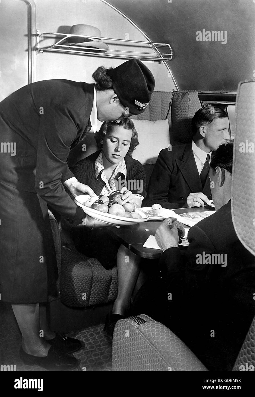 transport / transportation,aviation,airplanes,interior,Junkers Ju 90 of the Lufthansa,board service,stewardess serving fruit,1930s,30s,20th century,historic,historical,stewardess,air hostess,stewardesses,air hostesses,flight attendant,fruit,fruits,food,eat,eating,eaten,airplane,aeroplane,plane,airplanes,aeroplanes,planes,comfort,service,services,air passenger,air passengers,bumpee,catering,feeding,service,provision of food and drink,board,foods,meals,passengers,passenger,cabin,cabins,interior view,flight,flights,,Additional-Rights-Clearences-Not Available Stock Photo