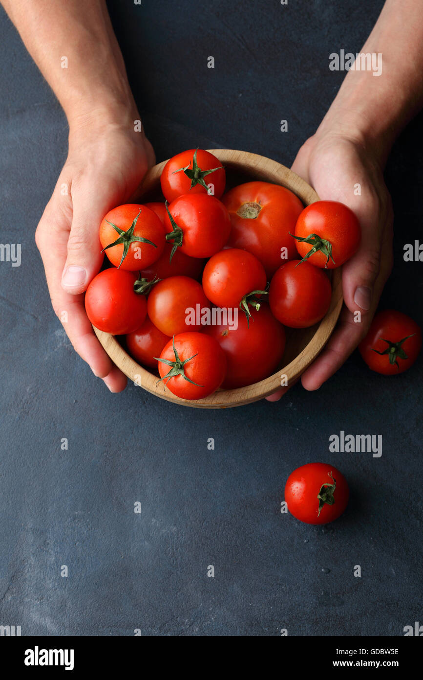 ripe tomatoes in wooden bowl, food background Stock Photo - Alamy