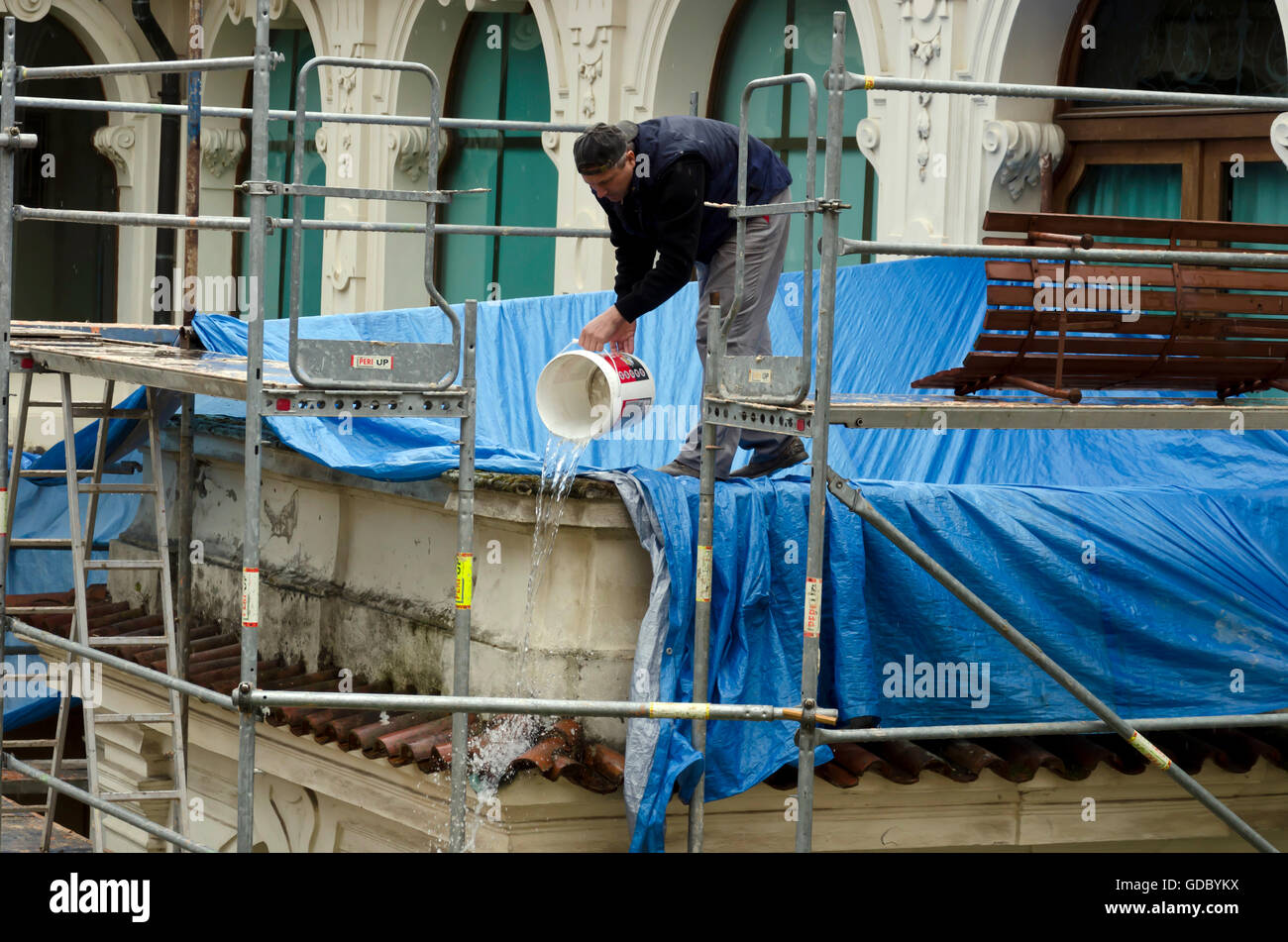 Workman pouring rainwater away at The Loreto (Loreta) in the centre of Prague (Praha) in the Czech Republic. Stock Photo