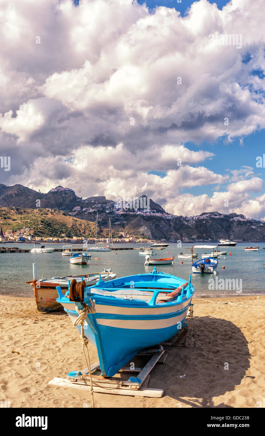 Fishing-boats at the beach,view towards Taormina on a mountain ridge Stock Photo