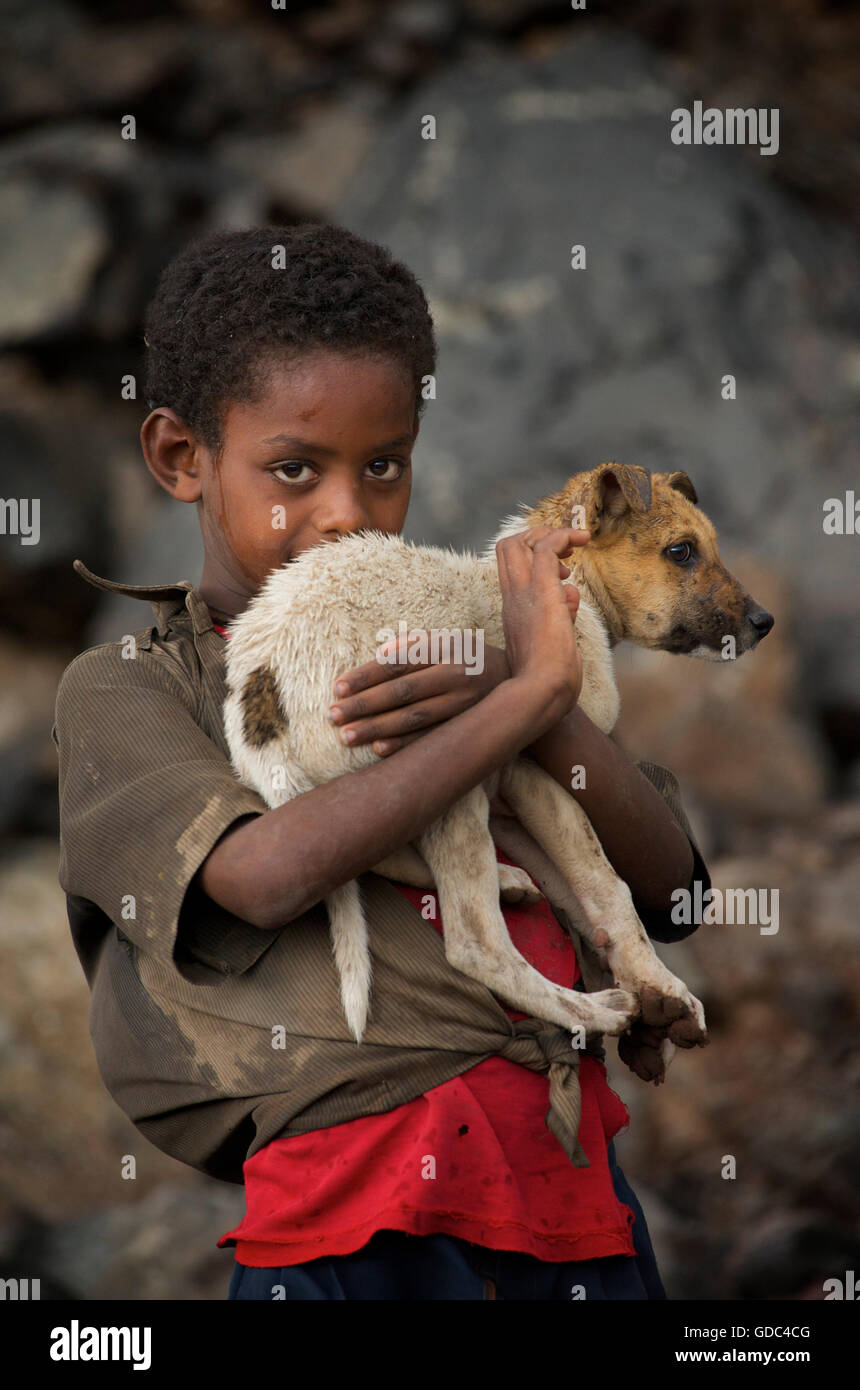 Ethiopian boy holding timid pet dog. The road to Debark, Ethiopia Stock